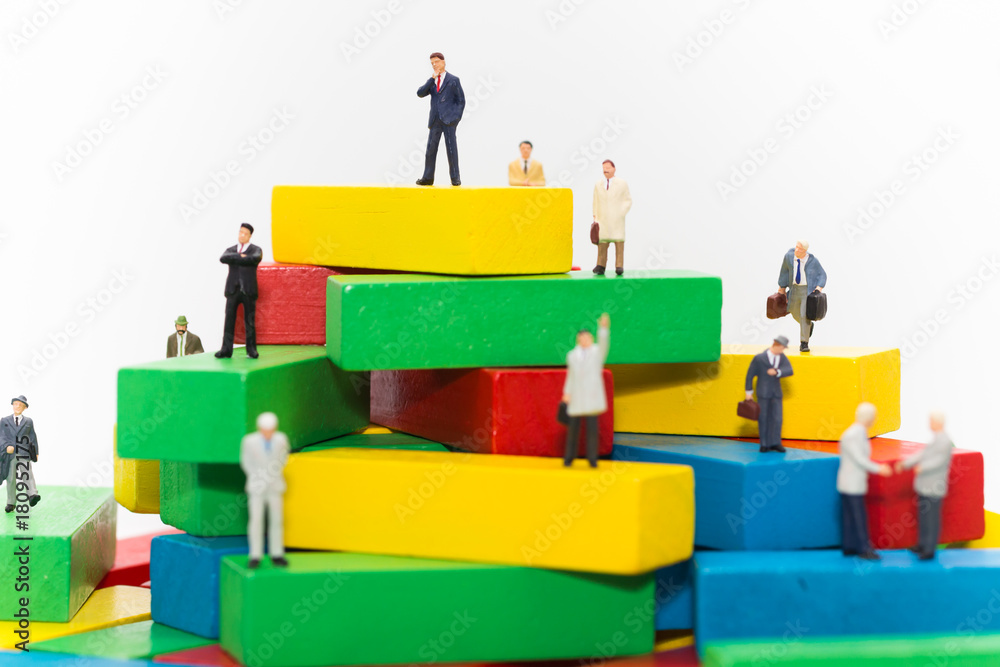 Businessman standing on wooden blocks color, used as a concept of business position.