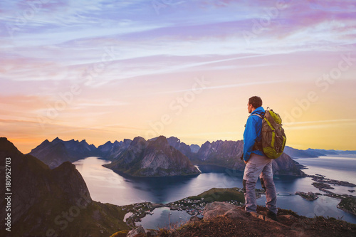 travel and adventure background, hiker with backpack enjoying sunset landscape in Lofoten, Norway