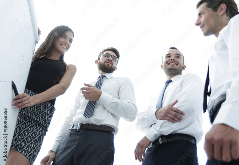 young business woman is colleagues their ideas on the flipchart. young business woman is colleagues their ideas on the flipchart.