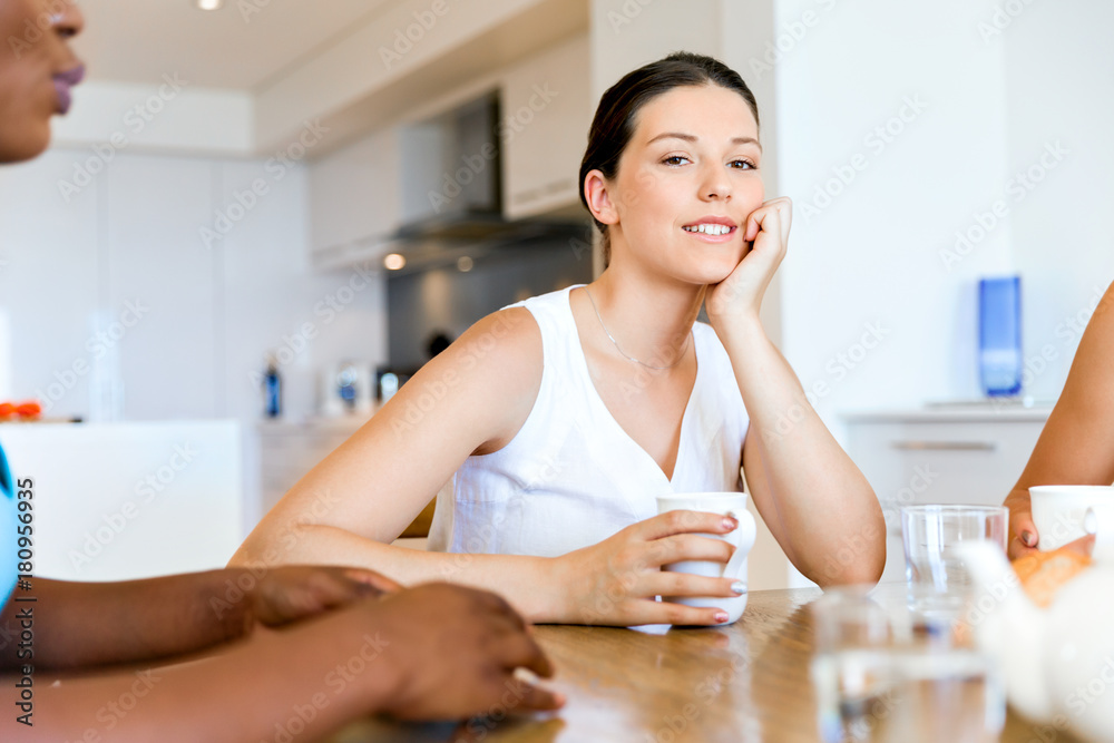 Happy young woman with cup of tea or coffee at home