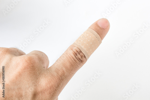 Adhesive bandage on index finger against white background