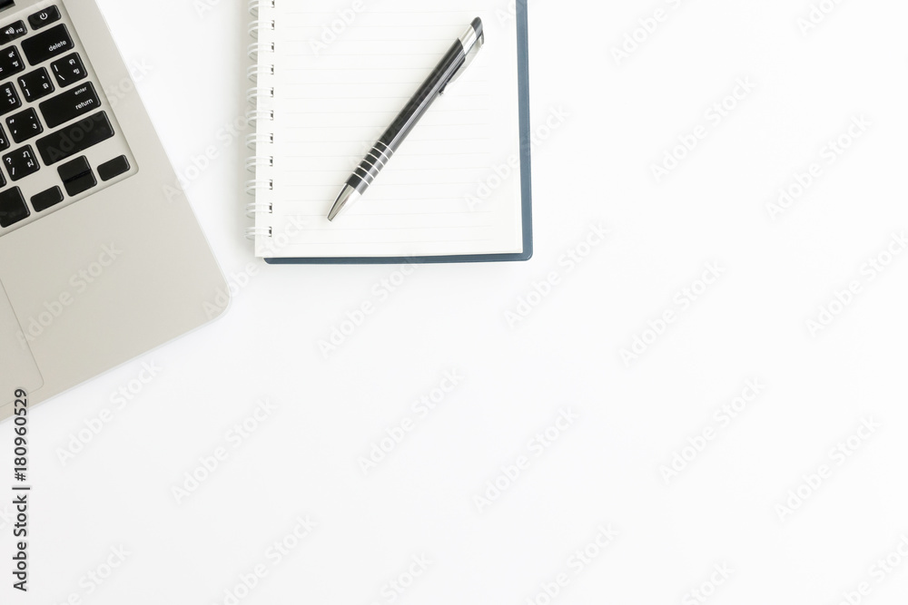 White office desk table with blank notebook, laptop computer, cup of coffee and supplies. Top view, flat lay. White office desk table with blank notebook, laptop computer, cup of coffee and supplies. Top view, flat lay.