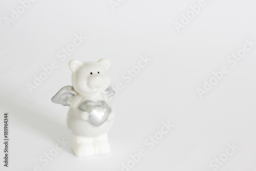 porcelain teddy bear with a heart on a white background. love © Stasiuk