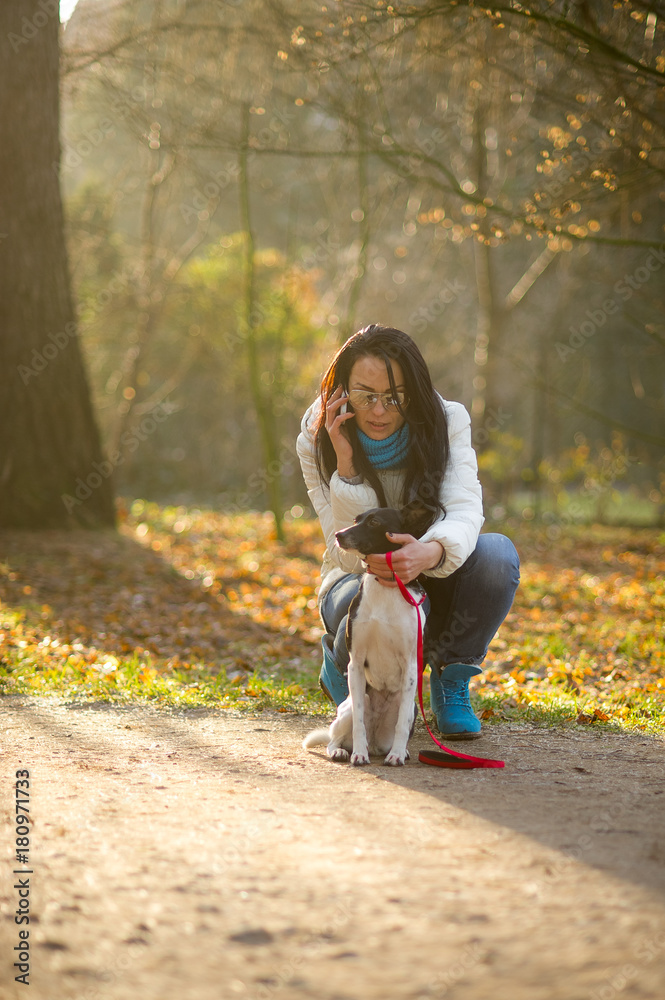 Obraz premium Young woman walking with her dog in autumn Park.