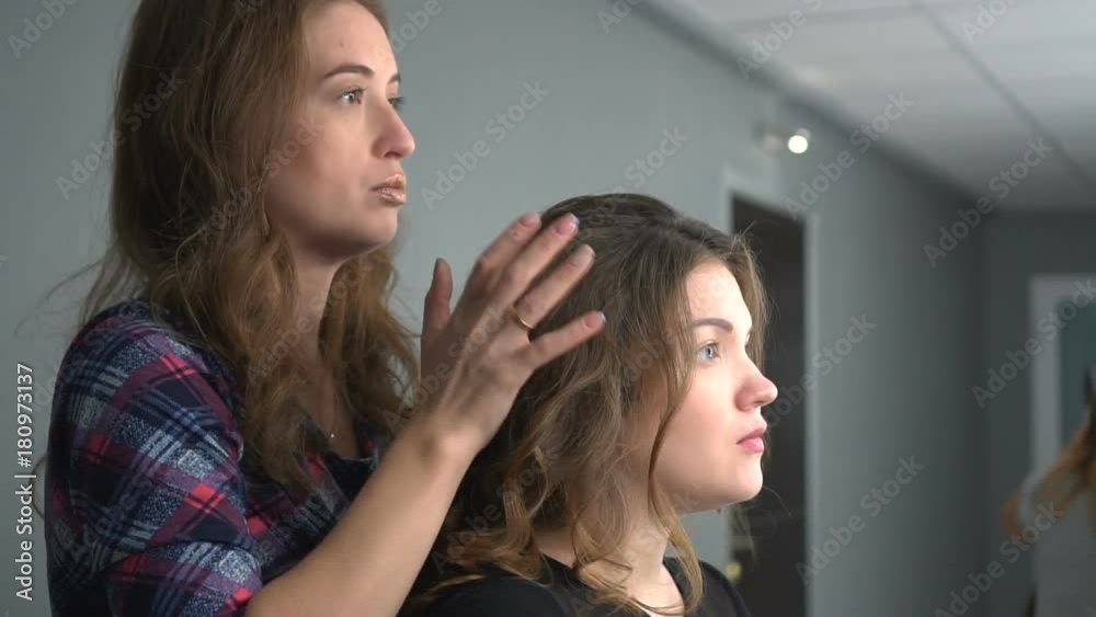 Young hairdresser giving a new haircut to female customer at parlor Young hairdresser giving a new haircut to female customer at parlor