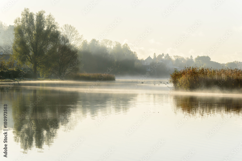 Misty autumn morning with reflections in the water