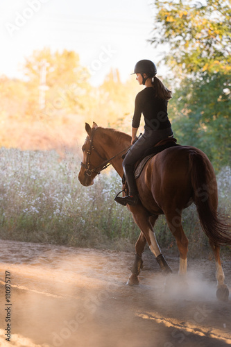 Młoda ładna dziewczyna - jazda na koniu z podświetlanymi liśćmi