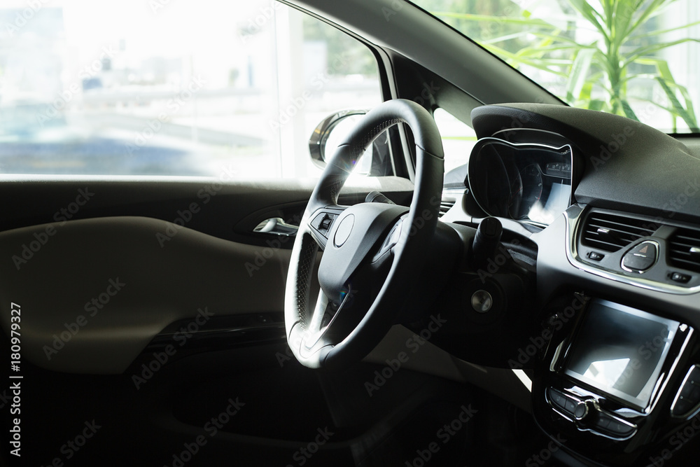 Inside a new car , view on a steering wheel and console, modern car interior Inside a new car , view on a steering wheel and console, modern car interior