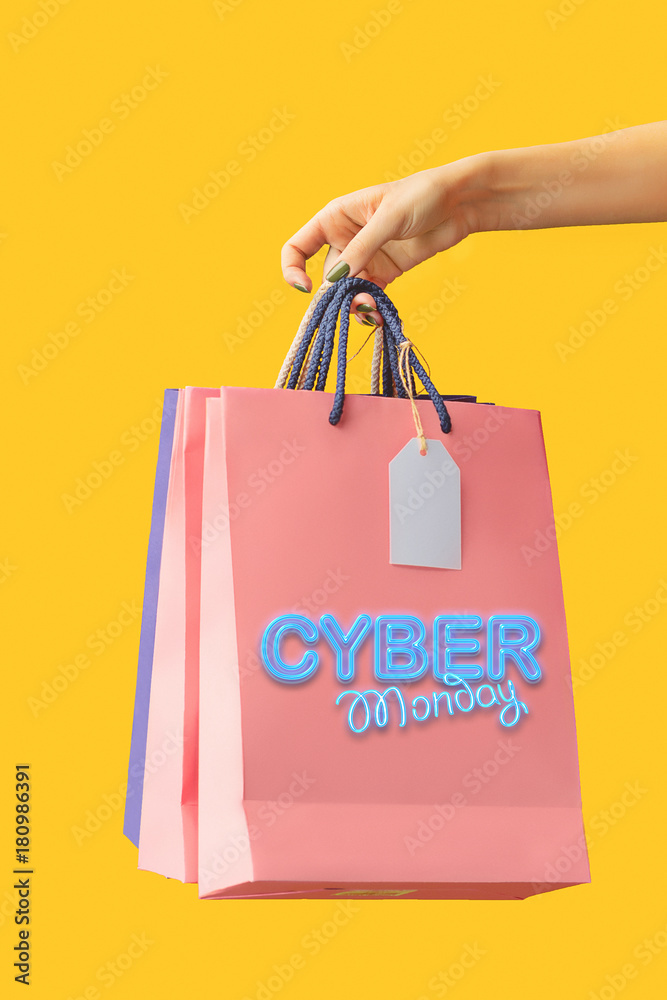 Female hand holding bright shopping bags Female hand holding bright shopping bags
