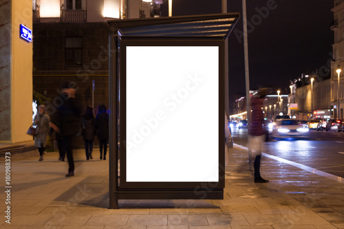 Blank white mock up of vertical light box in a bus stop at night