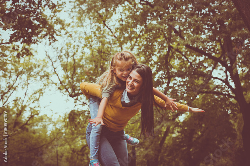 Mother playing with daughter. Outside.