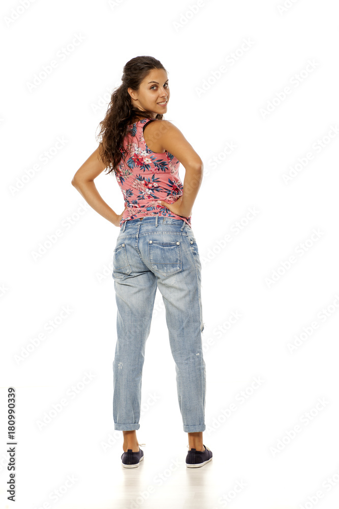 back view of young woman with torn jeans standing on white background back view of young woman with torn jeans standing on white background