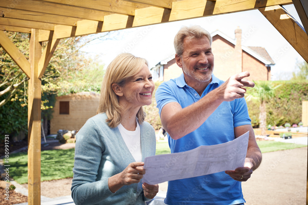 Naklejka premium Mature Woman Discusses Plan With Landscape Gardener