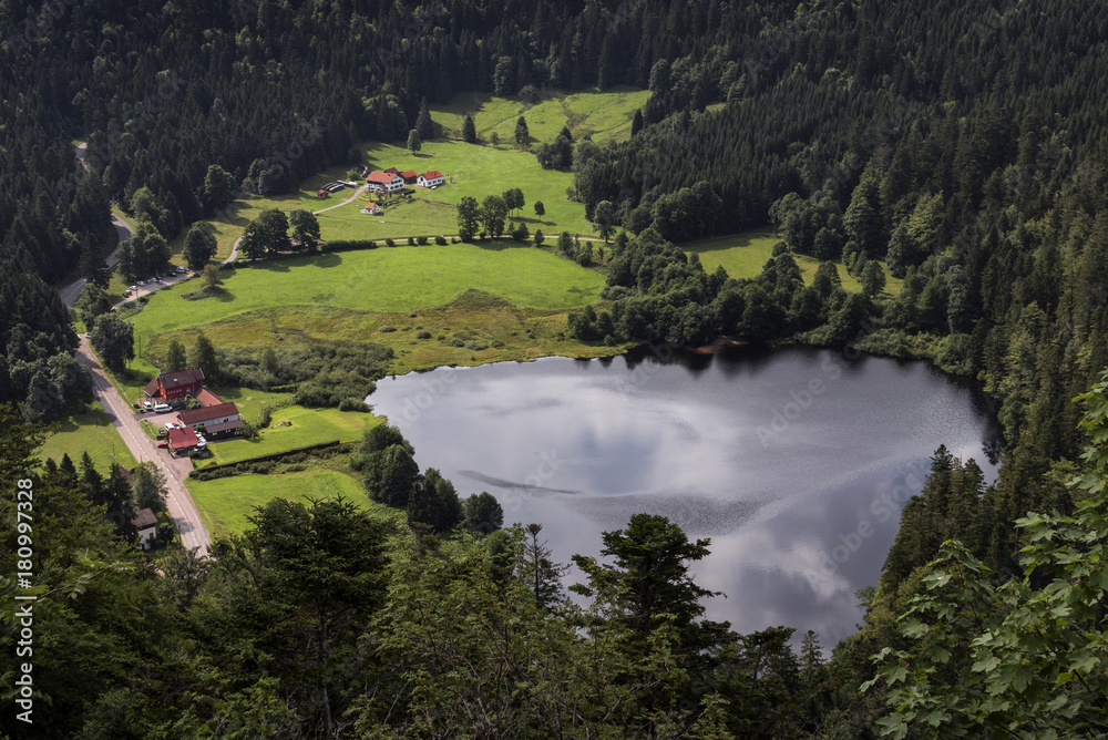 Obraz premium France, near Retournemer: Small lake and settlement in the woods - bird's eye perspective