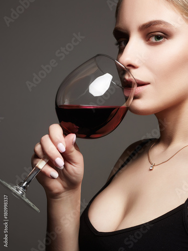 Beautiful sexy woman drinking red wine