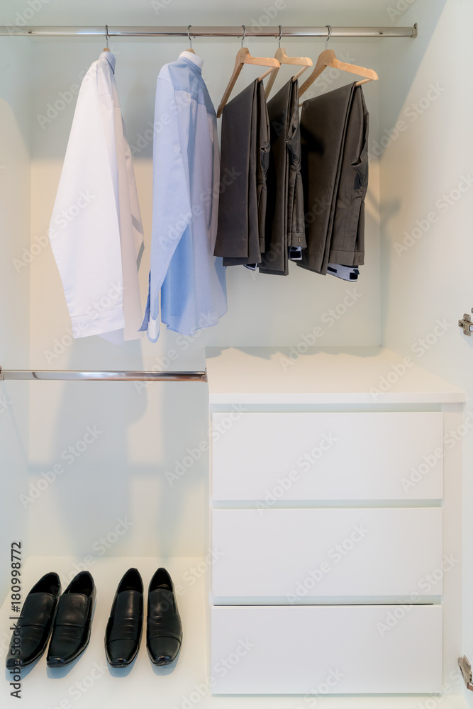 Modern interior wardrobe with man shirt, pants and shoes