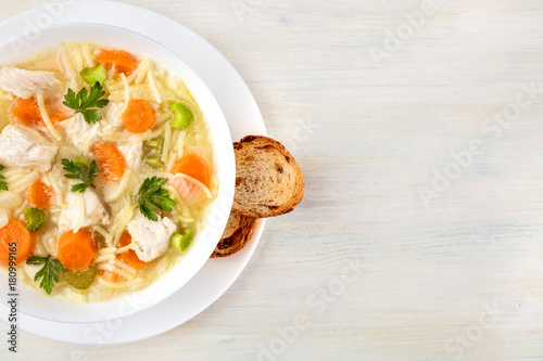 Chicken soup with noodles, overhead photo with copyspace