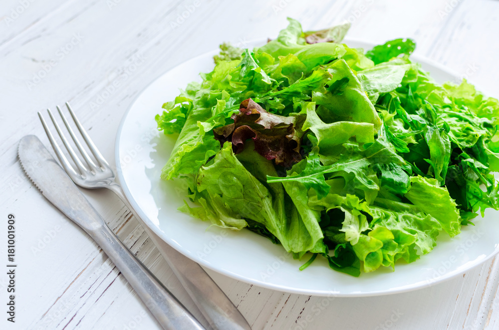 Lettuce salad mix on a wooden table Lettuce salad mix on a wooden table