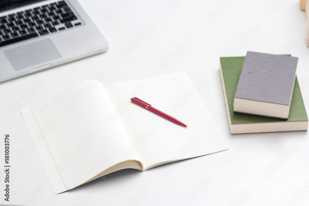 The office tool for work ,The blurry light design background of office tool for work ,laptop,book and  pen ,they are put on office deskop, mobile phone,paper work, pen ,they are put on office desk,