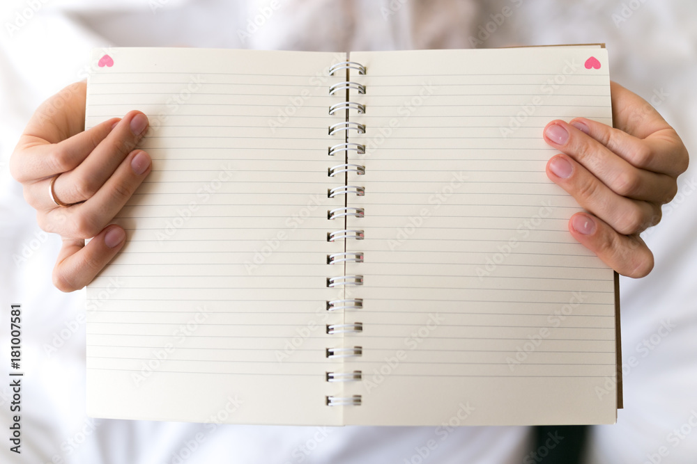 Girl, young women hold notebook. Hand, palm. Empty paper with hearts Girl, young women hold notebook. Hand, palm. Empty paper with hearts