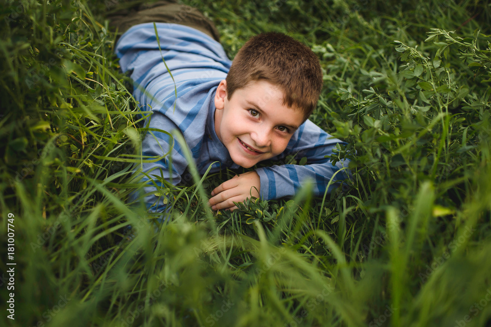 Boy looking up at camera on green grassy field Boy looking up at camera on green grassy field