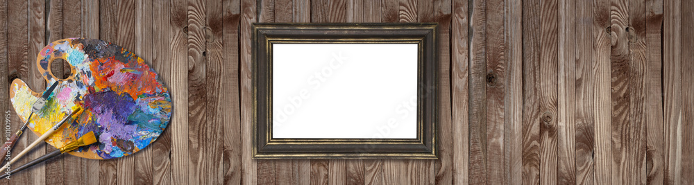 Palette for oil paints with brushes, palette knife and picture frames on shabby wooden background Palette for oil paints with brushes, palette knife and picture frames on shabby wooden background