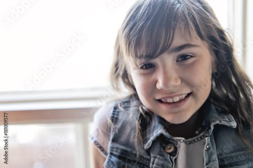Portrait of cute little girl close to the window