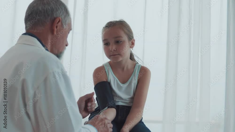 Senior doctor checking a small girl in his office. Senior doctor checking a small girl in his office.