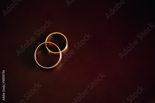 Gold wedding rings lie on a wooden table photo