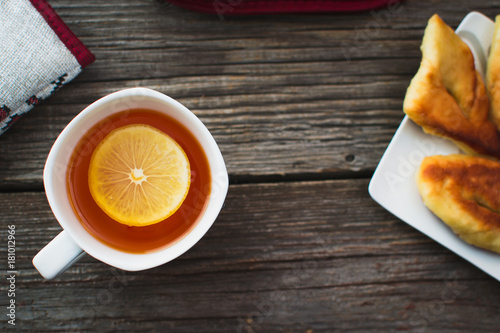 On wooden background, on the boards of toasted bread with tea and cakes