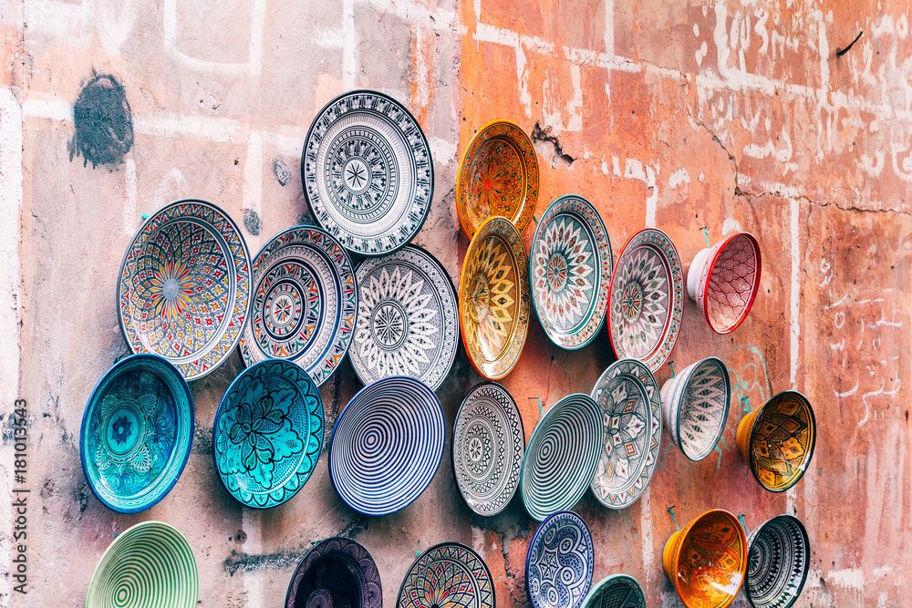colorful pottery plates hanging at wall, - obrazy, fototapety, plakaty 