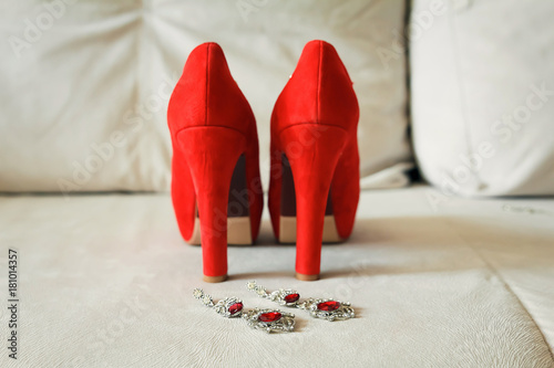 Red women's shoes stand on the windowsill, wedding, boutonniere. photo