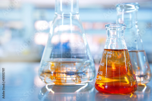 three glass flasks with chemical molecular structure in blue science laboratory background