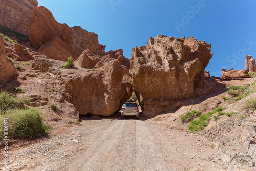 the car rides between two large stones in the Charyn canyon, Charyn Canyon in Kazakhstan. The Valley of Castles.