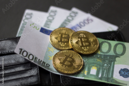 Golden bitcoins and banknotes Euro in my wallet on a black background. the new virtual money