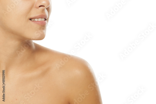 Smile, neck and shoulder of a young woman without makeup
