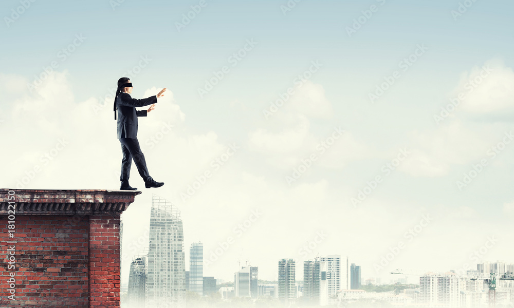 Danger and risk concept with businessman making step from edge Danger and risk concept with businessman making step from edge