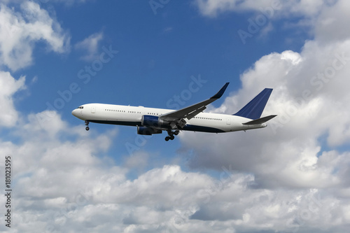 Commercial airplane landing at the airport with cloudy sky in the background
