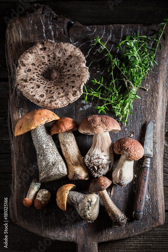 Various mushrooms and thyme on the old board