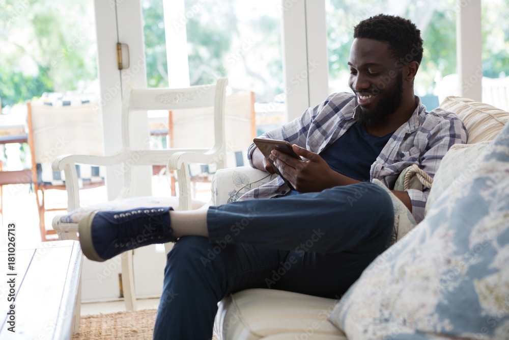 Man using digital tablet in living room Man using digital tablet in living room