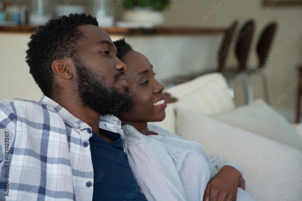 Couple watching television together in living room