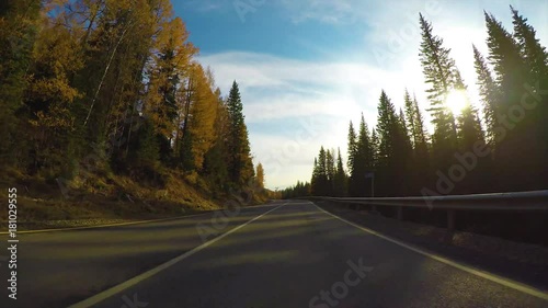 Driving down a quiet rural highway during the day in autumn.