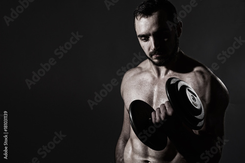 Young muscular man with dumbbells