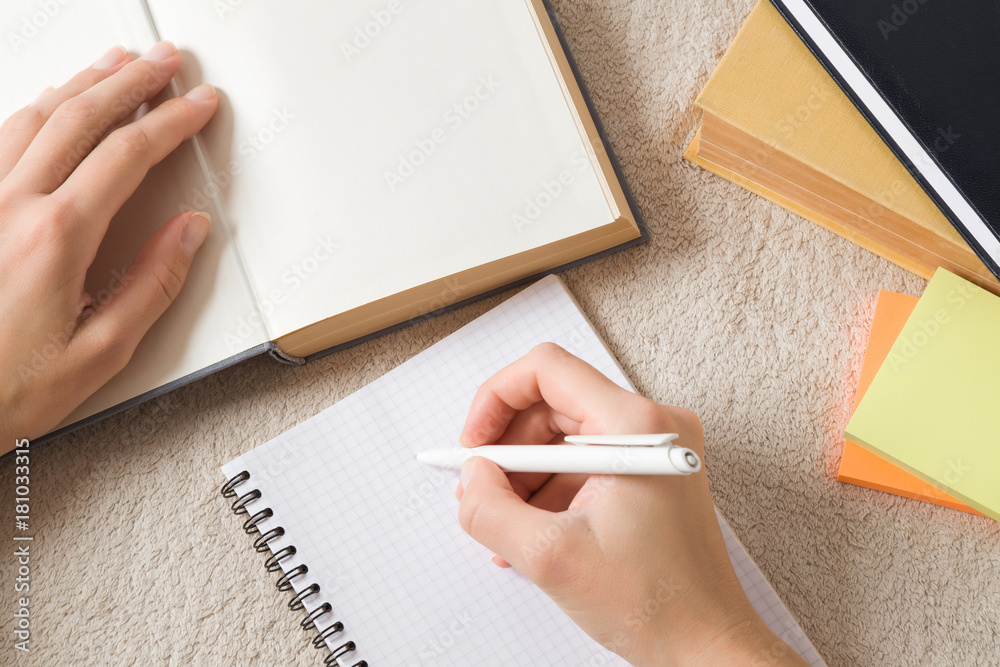 Student doing homework in the notepad in the bed. Preparation for the exam. Education concept. Empty place for a text. Student doing homework in the notepad in the bed. Preparation for the exam. Education concept. Empty place for a text.