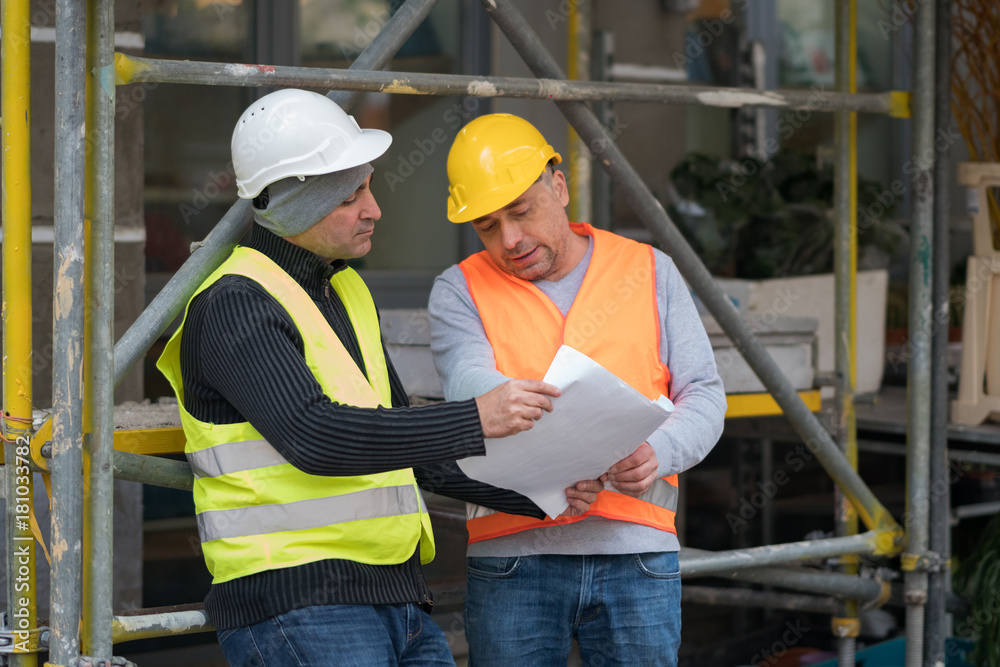 Engineer giving colleague arrangements about a new construction site. Outdoors Engineer giving colleague arrangements about a new construction site. Outdoors