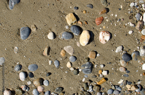 Colorful sea stones and sand background. Pebbles texture