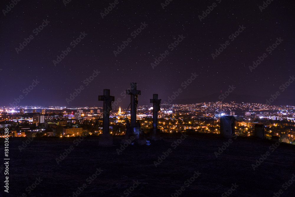 City night in Nitra from the view point on top of Hill (mountain) Slovak city Nitra with purple night sky and crosses.  City center at night with buildings and churches. City at night with stars