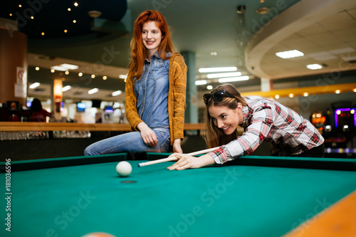 Beautiful women playing billiards