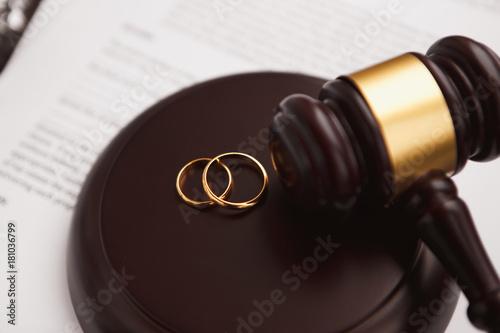 Divorce concept with gavel and wedding rings photo