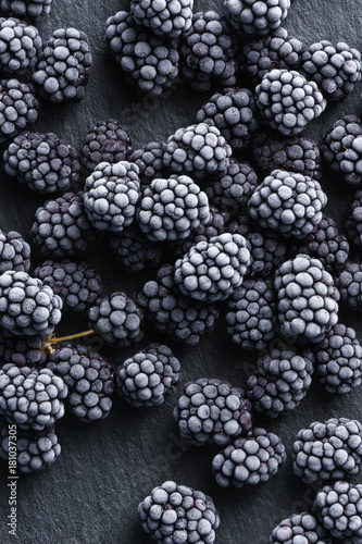 Frozen blackberry on black slate. Top view. High resolution product.